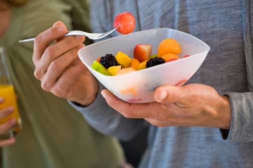 man eating from a bowl of fruit salad