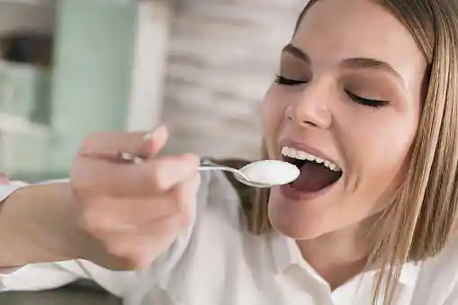 woman eating a spoonful of sugar=
